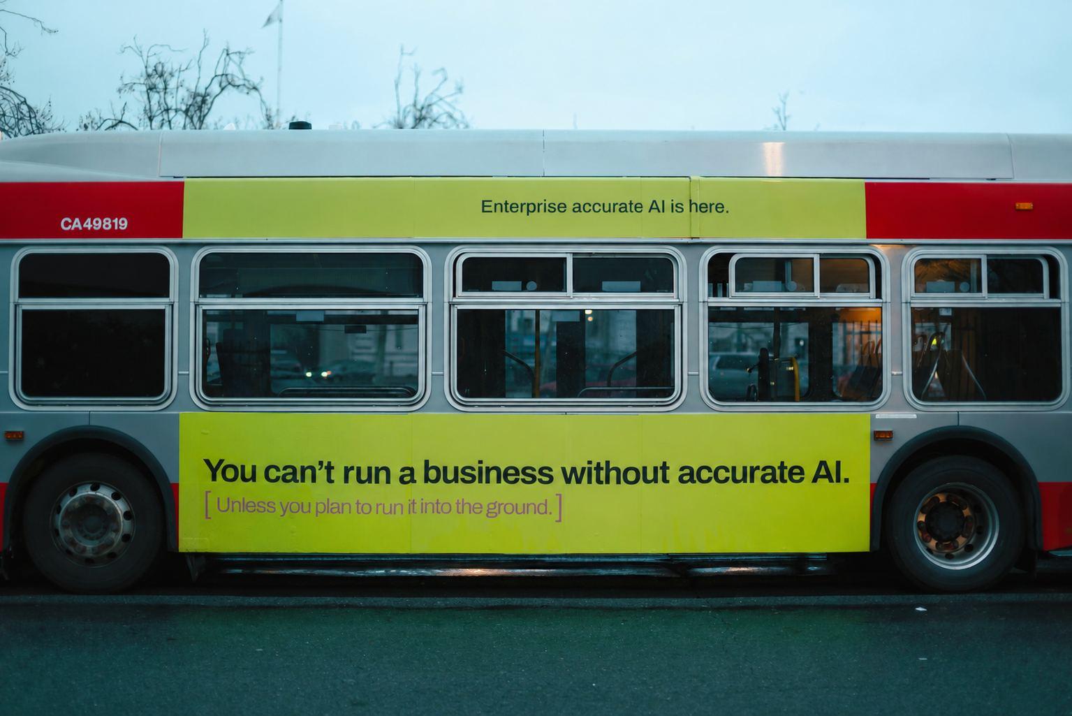 Bočna strana gradskog autobusa sa žutom reklamom na kojoj piše „You can’t run a business without accurate AI.”