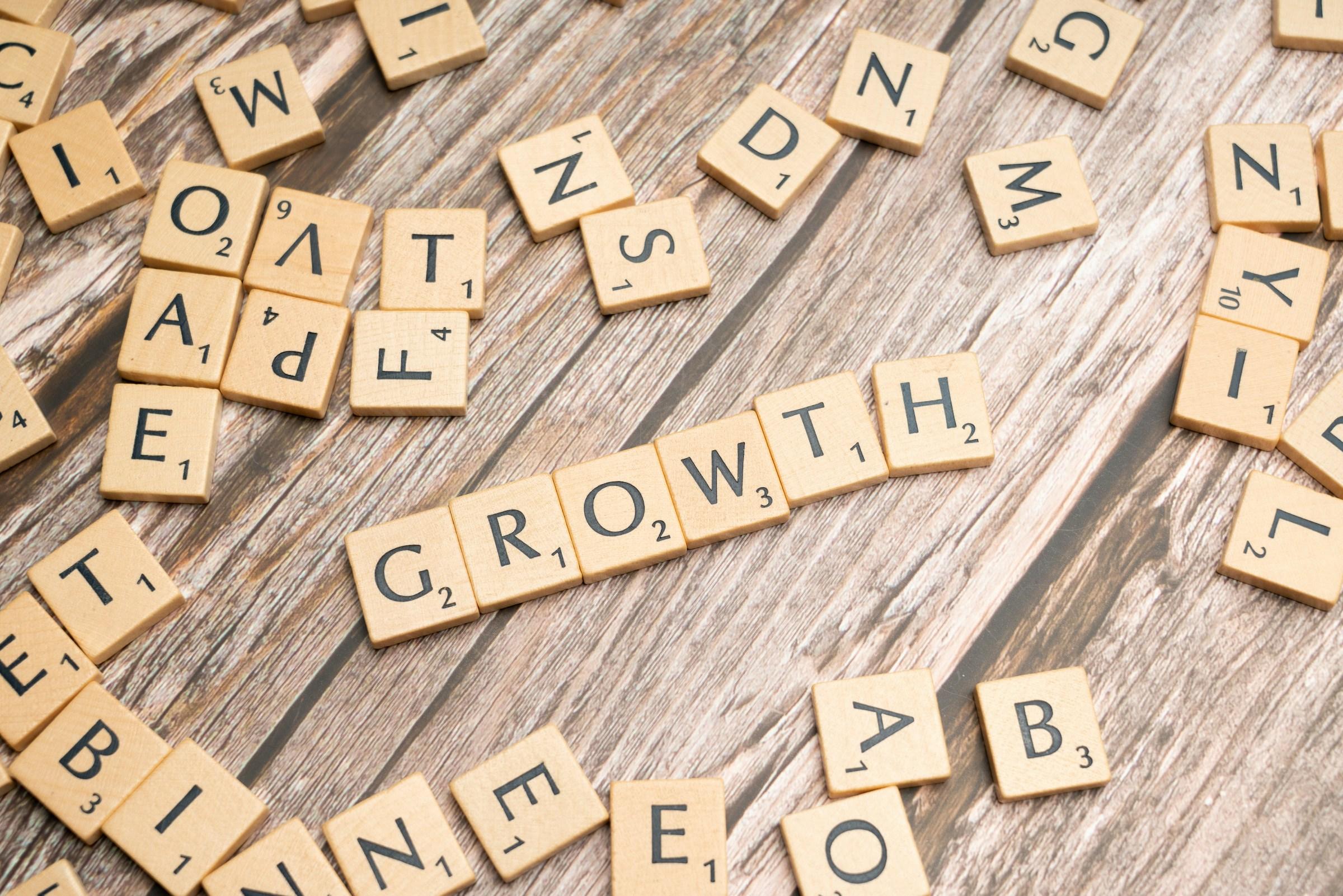 Drvene pločice sa slovima koje formiraju reč GROWTH na drvenoj podlozi