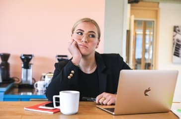 Žena za laptopom razmišlja o konstruktivnom feedbacku i njegovom uticaju na samopouzdanje i profesionalni razvoj